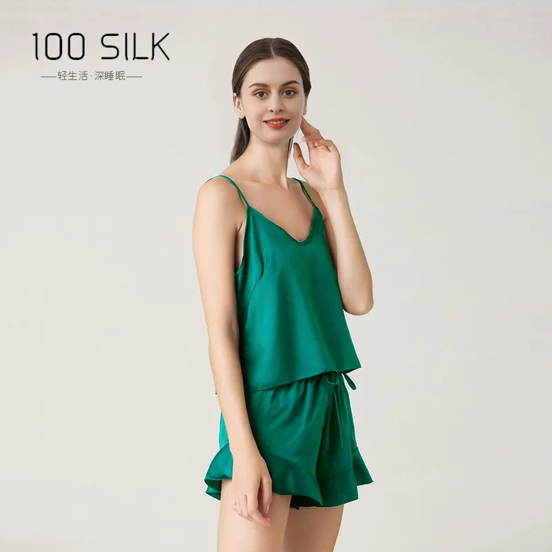 Woman wearing a green silk dress with '100 SILK' branding on a light gray background