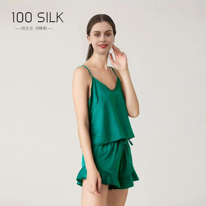Woman wearing a green silk dress with '100 SILK' branding on a light gray background