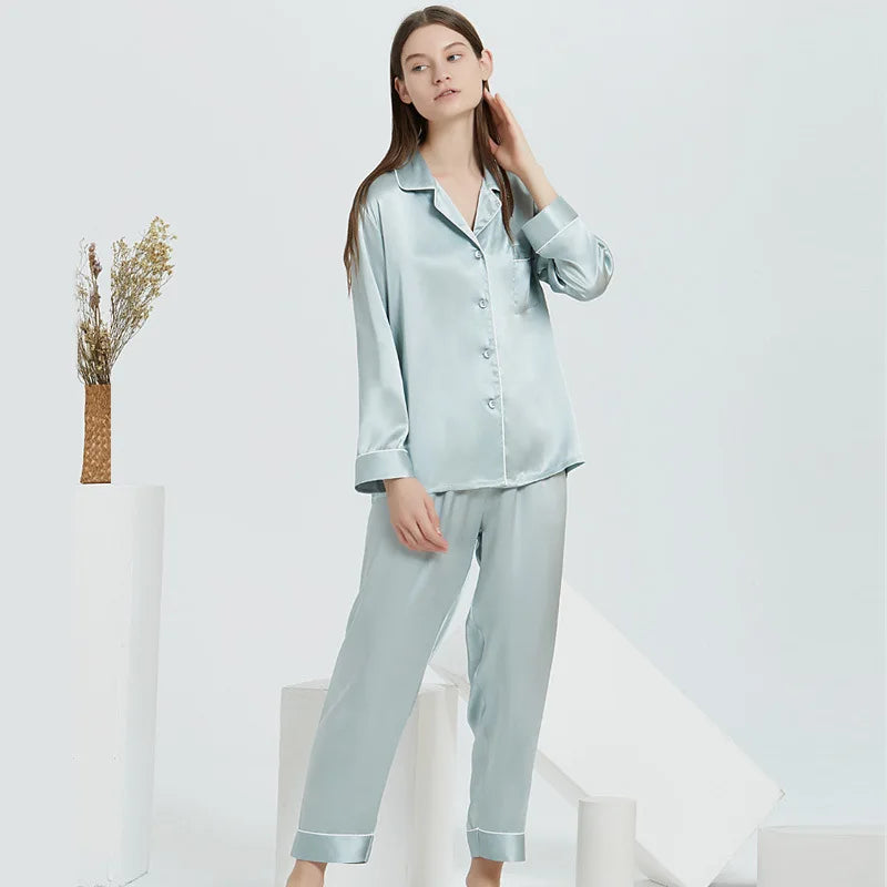 Woman wearing light blue satin pajamas against a white background