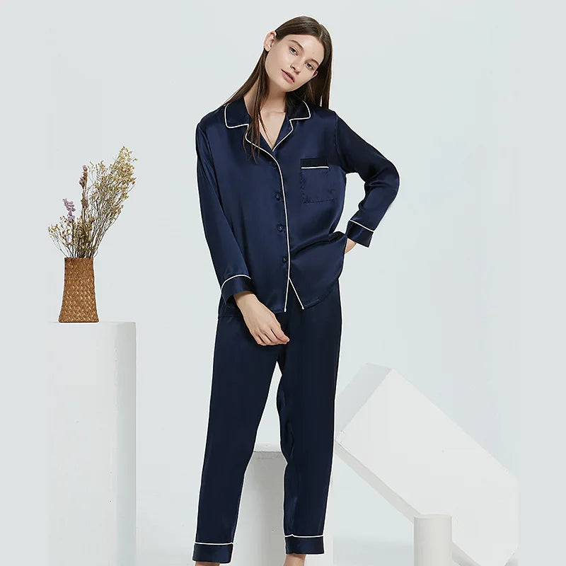 Woman wearing navy blue pajamas with white trim on a white background
