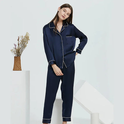Woman wearing navy blue pajamas with white trim on a white background