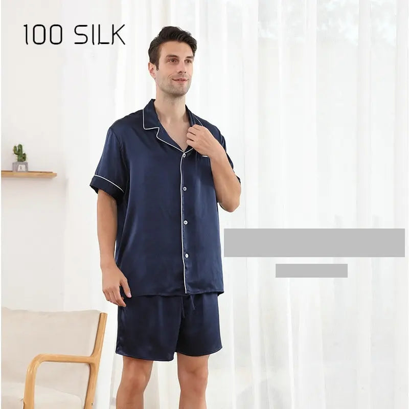 Man wearing navy silk pajama set with '100 Silk' text on a white background