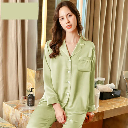 Woman wearing green pajamas sitting on a bed in a bedroom setting.