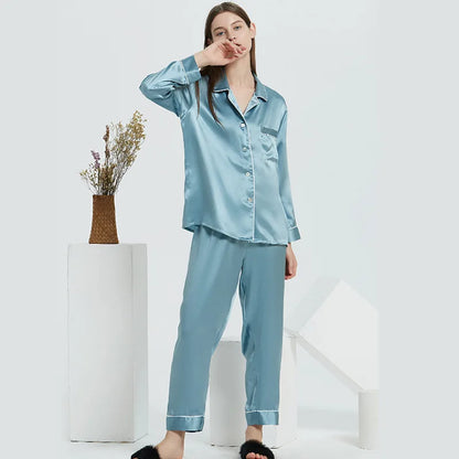 Woman wearing a light blue satin pajama set on a white background