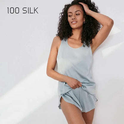 Woman wearing a light blue silk dress with '100 SILK' text on a white background