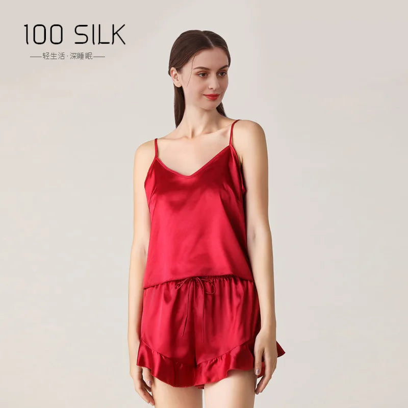 Woman wearing a red silk nightgown with '100 Silk' branding on a light background