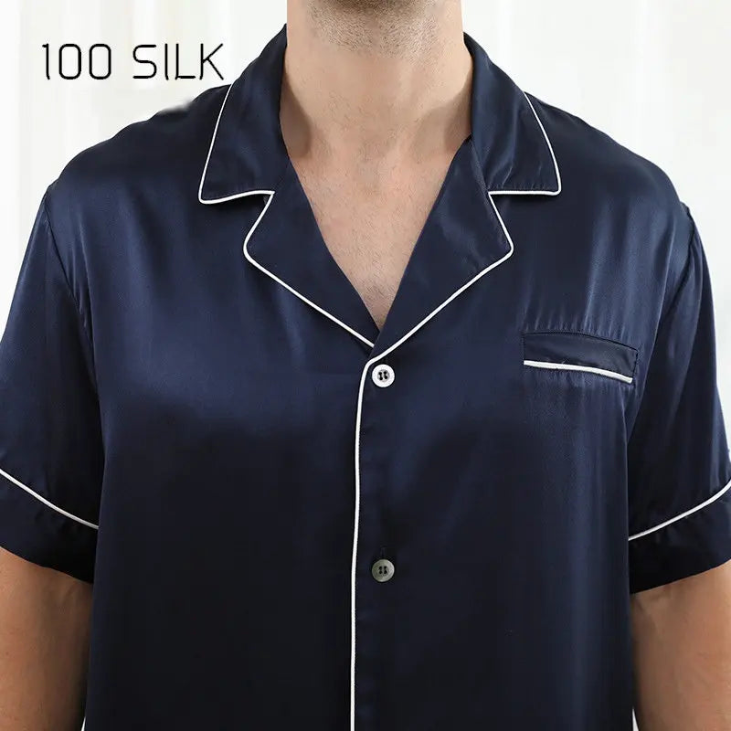 Navy silk pajama top with white piping on a white background