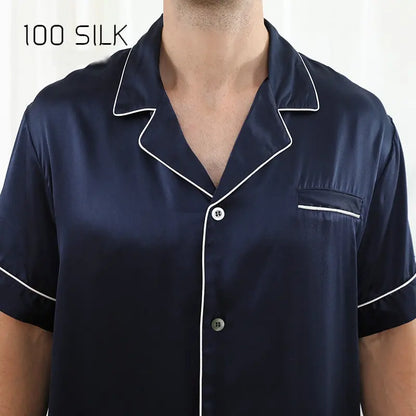 Navy silk pajama top with white piping on a white background