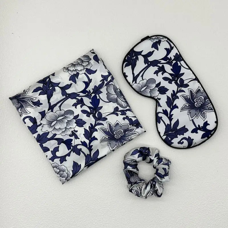 Set of floral-patterned eye mask, pouch, and scrunchie on a white background