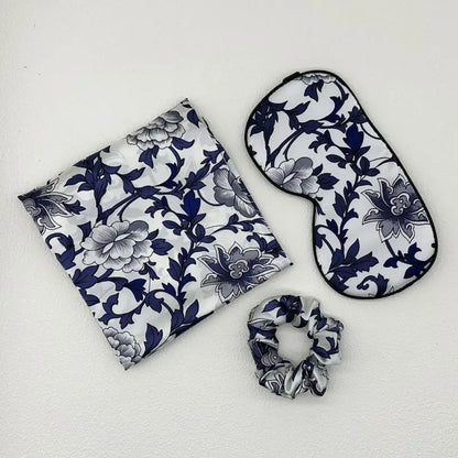 Set of floral-patterned eye mask, pouch, and scrunchie on a white background