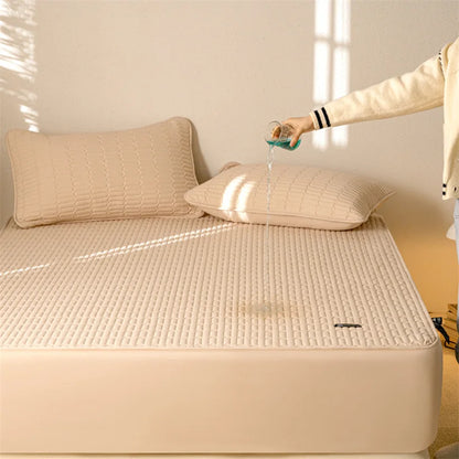 Beige mattress cover with pillows on a bed, person pouring water onto it.