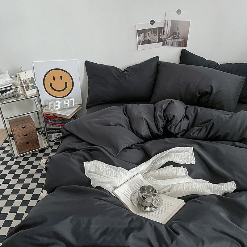 Black bedding set on a bed with a checkered floor and wall decorations.