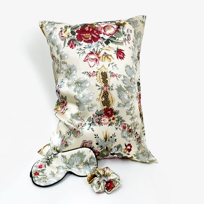 Floral-patterned pillow, eye mask, and scrunchie set on a white background