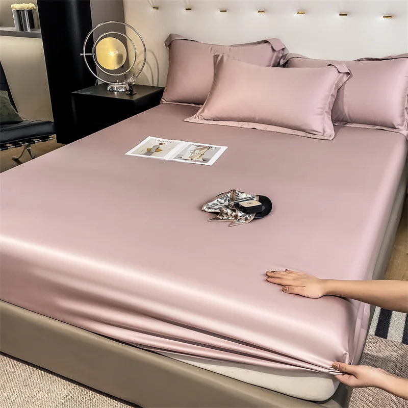 Person adjusting a pink satin sheet on a bed in a bedroom setting.